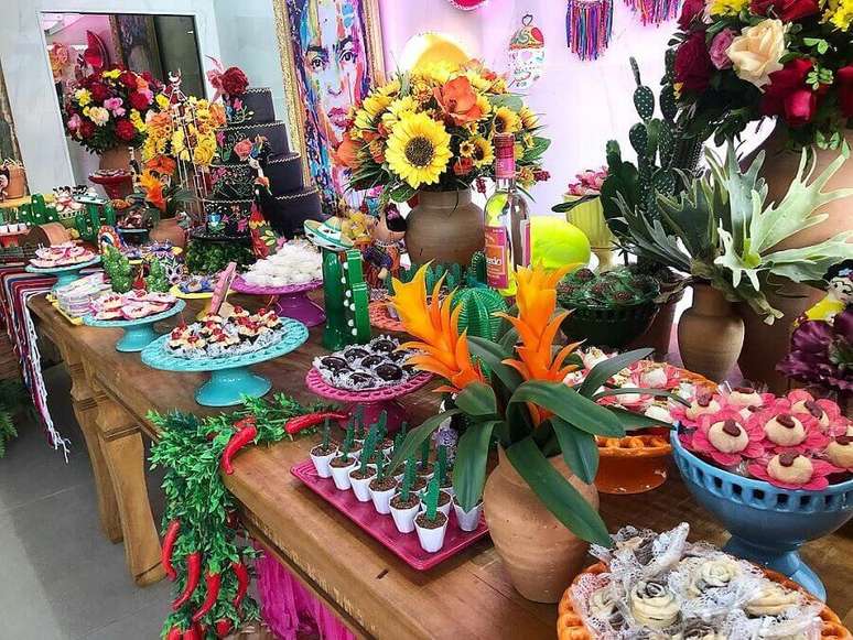 30. Decora&ccedil;&atilde;o festa mexicana com grandes arranjos de flores e v&aacute;rios pratos coloridos para doces &ndash; Foto: Bello Toque