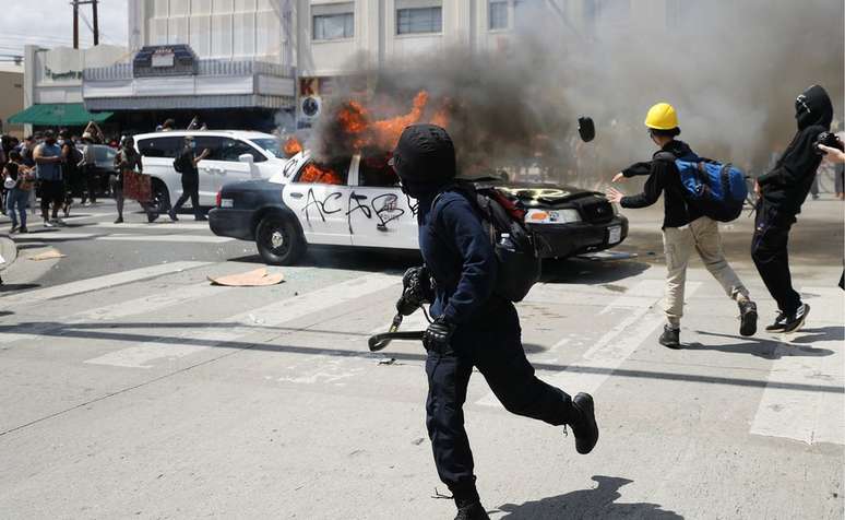 Oficiais da tropa de choque e manifestantes que atearam fogo em viaturas entraram em confronto em Los Angeles, n Califórnia