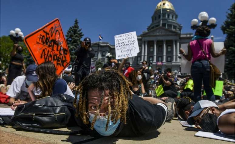 Multidão participa de de uma manifestação ao lado do Capitólio de Denver, no Estado do Colorado com as mãos atadas nas costas