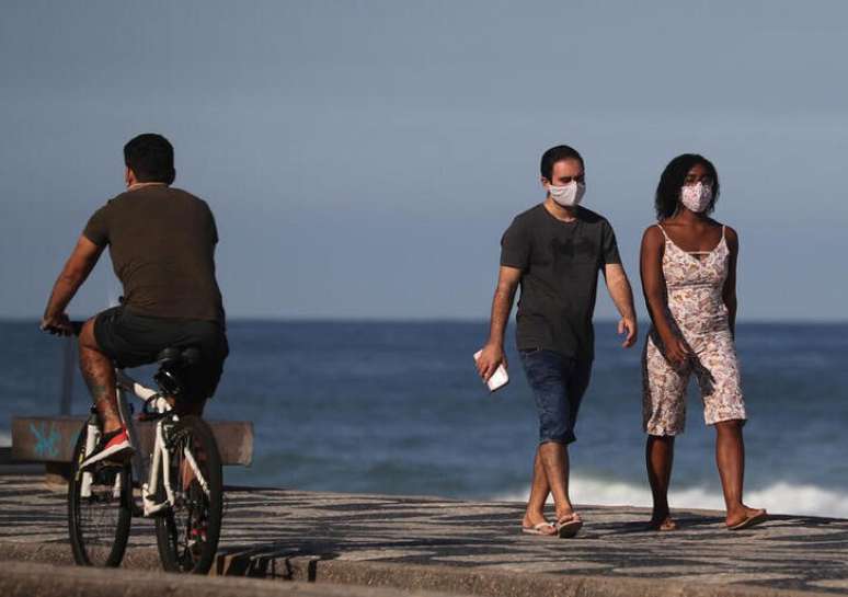 Casal com máscara de proteção caminha perto da praia do Leblon, no Rio de Janeiro
25/05/2020 REUTERS/Sergio Moraes