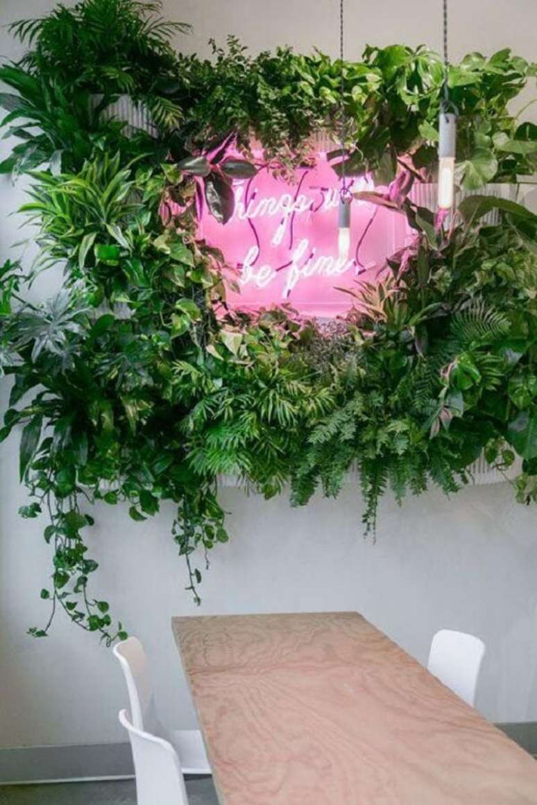 16. Sala de jantar com letreiro luminoso neon e jardim vertical artificial traz um toque tropical para a decoração. Fonte: Pinterest