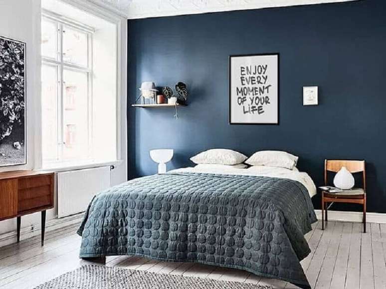 41. Quadros com frases para quarto de casal azul com criado mudo de madeira – Foto: Enquadrarte