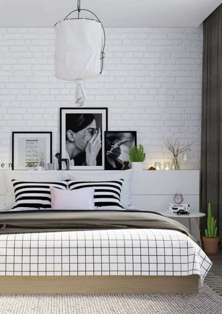 47. Quadros com frases para quarto de casal preto e branco com parede de tijolinho branco – Foto: Pinosy
