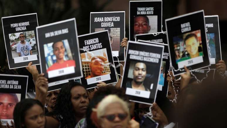Jovens são as principais alvos de homicídio no país; acima, moradores do Rio levantam cartazes de vítimas da violência em protesto no ano passado