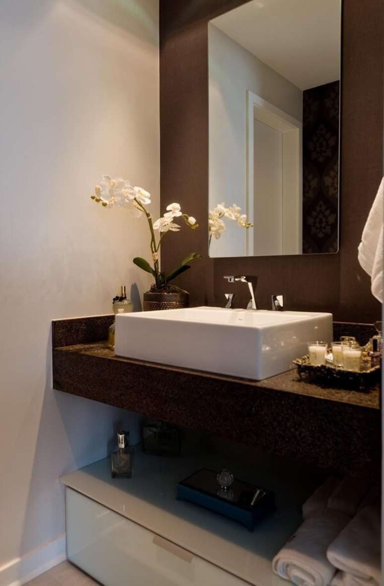 15. A cuba branca se destaca sobre a bancada do banheiro feita com granito café imperial. Projeto por Archdesign Studio