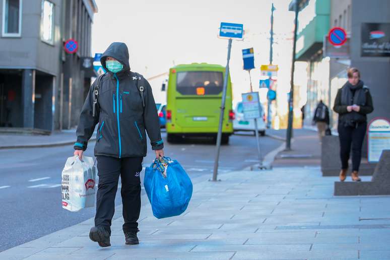 Homem com m&aacute;scara de prote&ccedil;&atilde;o carrega sacola de compras em rua de Oslo
13/05/2020 NTB Scanpix/Hakon Mosvold Larsen via REUTERS 