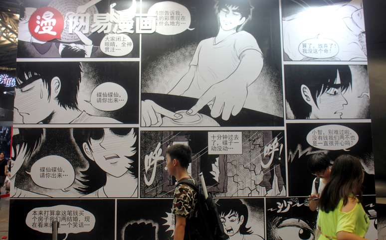 Pessoas passam pela frente de desenhos da NetEase Comics, em Xangai. 6/7/2017. REUTERS/Stringer  ATTENTION EDITORS - THIS IMAGE WAS PROVIDED BY A THIRD PARTY. CHINA OUT.