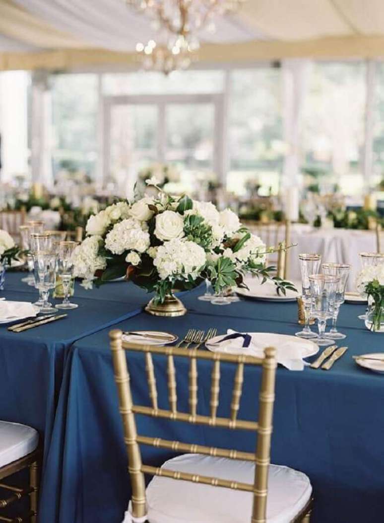 32. Decoração de casamento azul e dourado com arranjo de flores brancas – Foto: Style Me Pretty