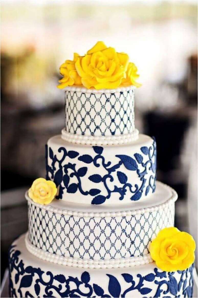 47. Flores amarelas para decoração de bolo de casamento azul e branco – Foto: Weddbook
