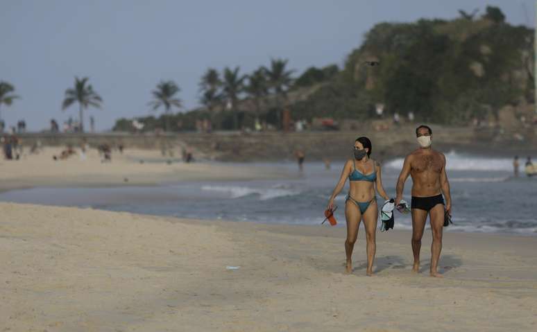 Casal com máscara de proteção caminha na praia do Arpoador, no Rio de Janeiro
06/06/2020 REUTERS/Ricardo Moraes