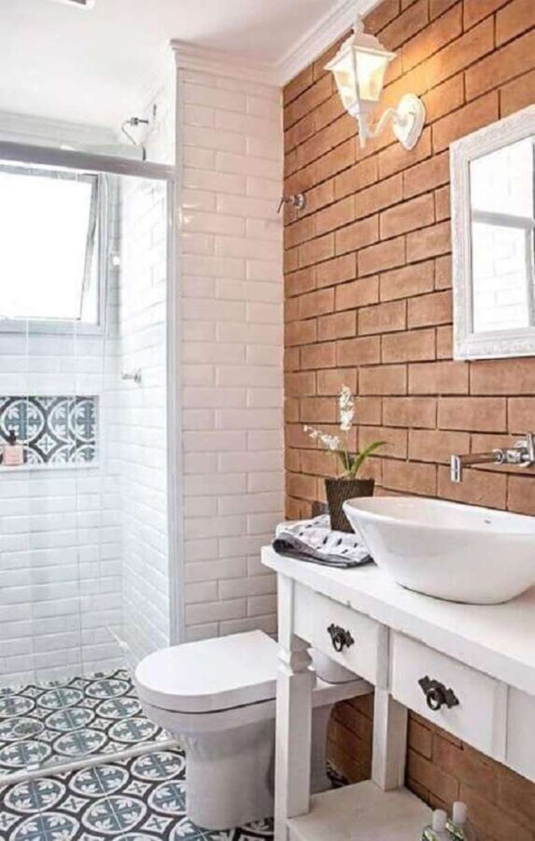 29. Banheiro rústico simples decorado com piso hidráulico e parede de tijolinho à vista – Foto: Pinterest