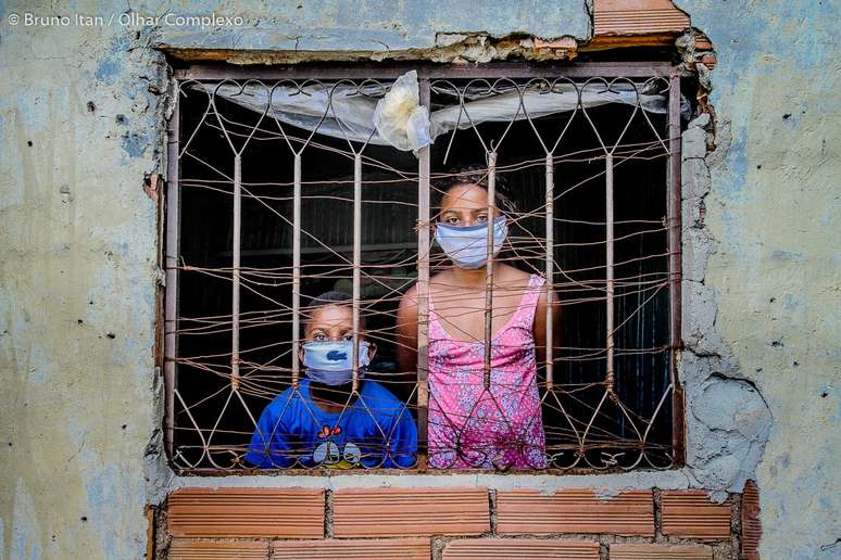 Duas crianças seguem à risca a quarentena imposta pela covid-19 no Complexo do Alemão