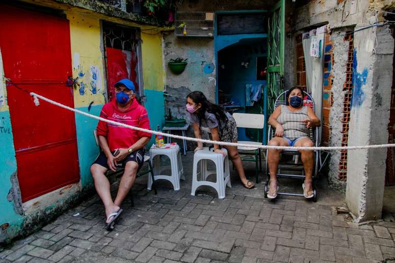 Família impõe distância mínima esticando uma corda em frente de casa numa favela do Rio