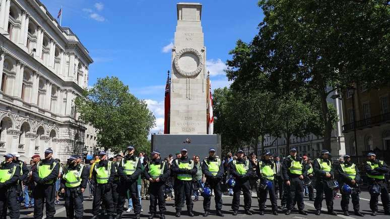 Policiais em frente a memorial de guerra em Whitehall, Londres, durante manifestação neste sábado