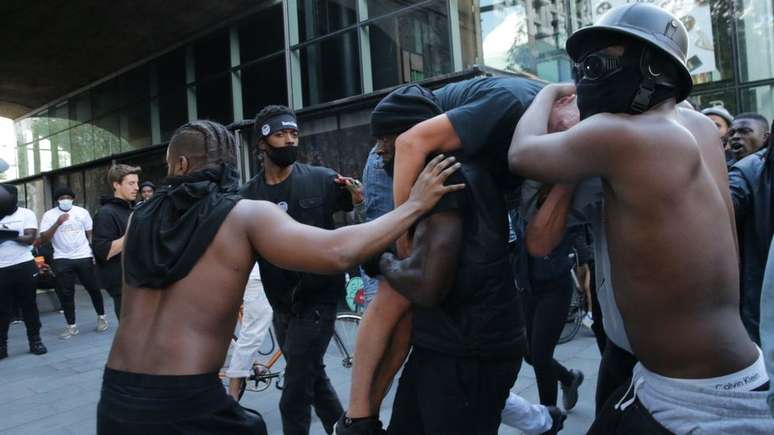 Os amigos de Hutchinson tiveram que protegê-lo enquanto carregava manifestante para que eles não fossem agredidos