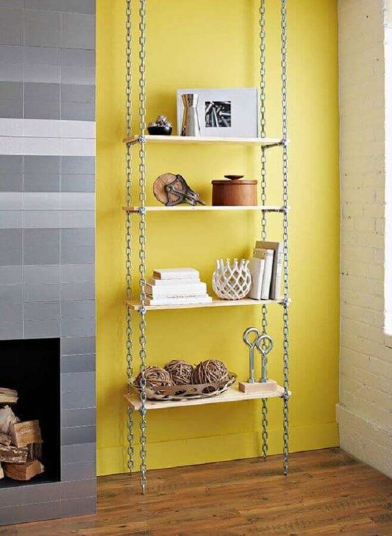 21. Parede amarela decorada com prateleira suspensa com correntes – Foto: Pinterest