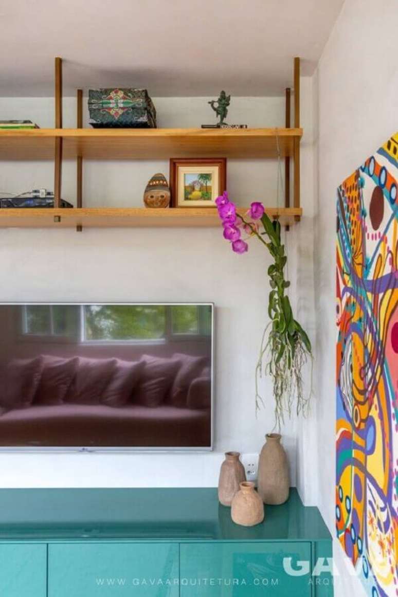 62. Sala de TV decorada com rack azul e prateleira suspensa teto – Foto: GAVA Arquitetura