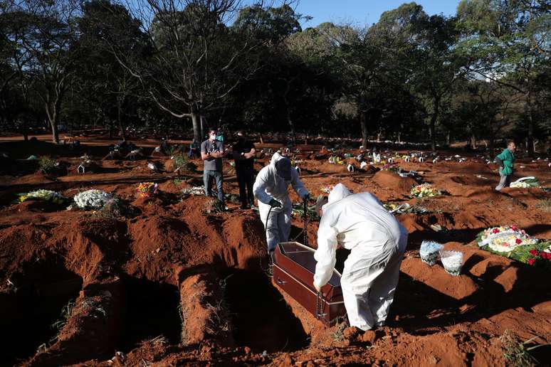 Coveiros com traje de prote&ccedil;&atilde;o se preparam para sepultar no cemit&eacute;rio de Vila Formosa, em S&atilde;o Paulo, mulher que morreu devido ao novo coronav&iacute;rus
26/05/2020
REUTERS/Amanda Perobelli