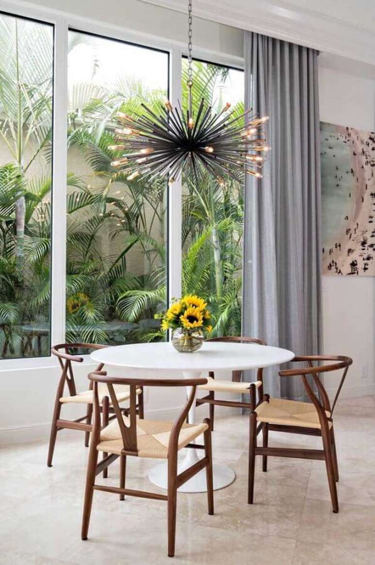 15. Modelo pequeno de vaso de flor para mesa de jantar redonda com lustre moderno em cima – Foto: Pinterest