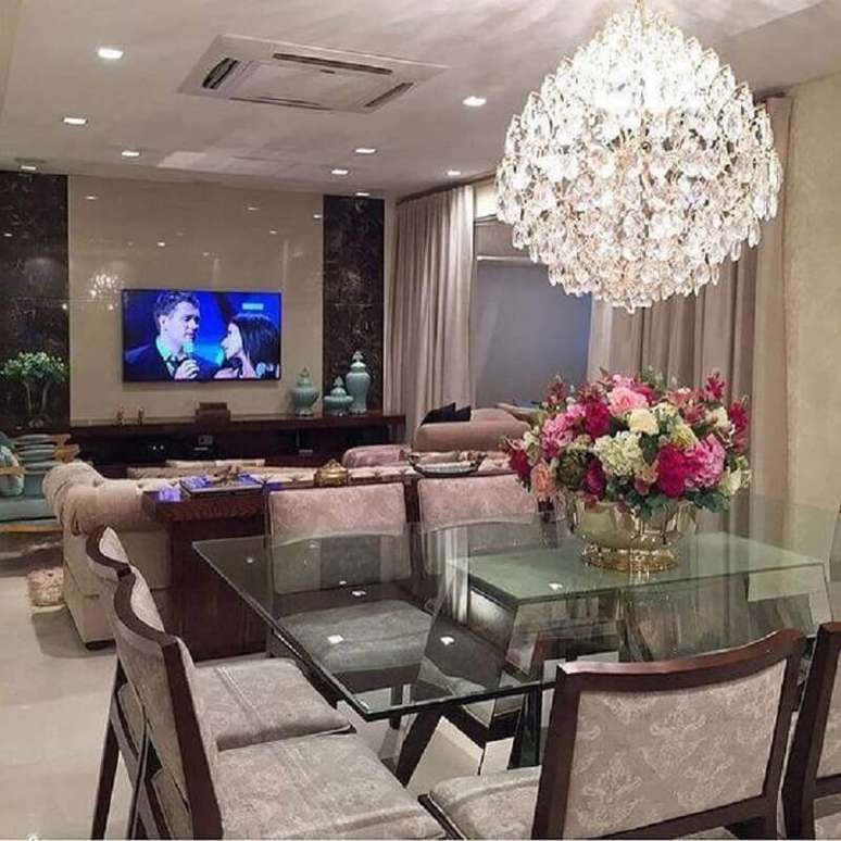 21. Decoração para sala de jantar com lustre de cristal e vaso de metal com arranjo de flores – Foto: Pinterest