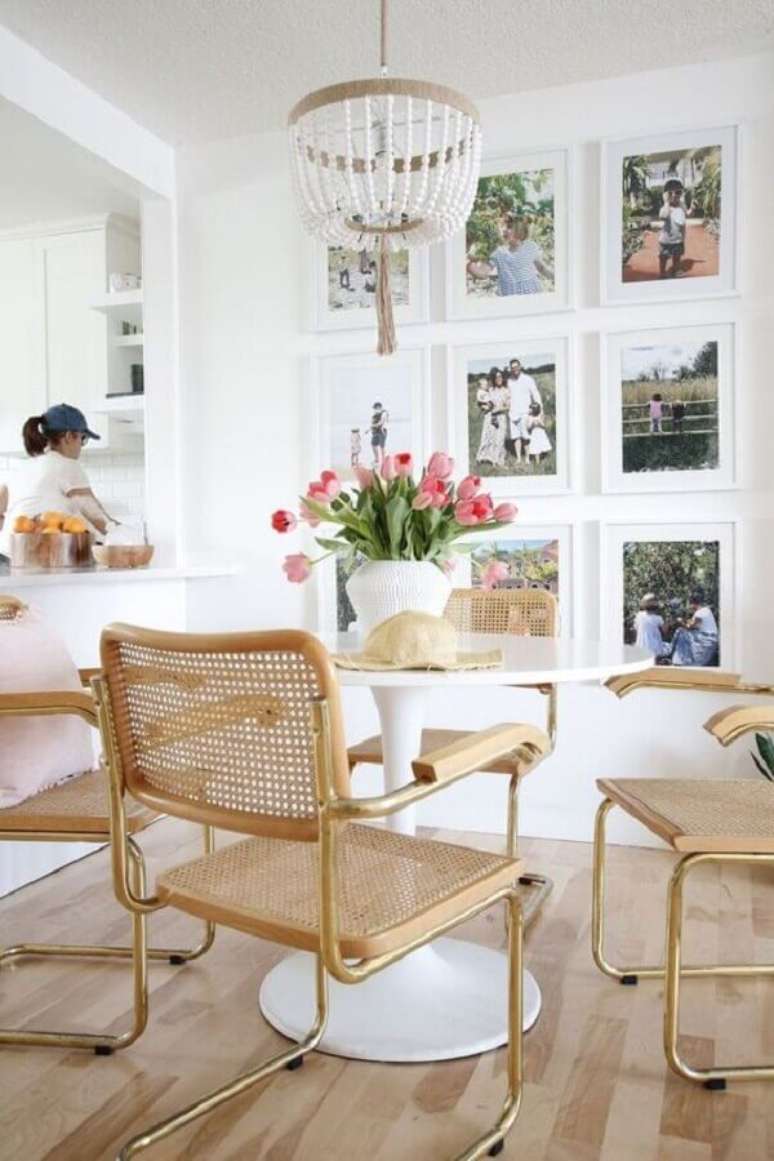 31. Sala de jantar branca decorada com vários quadros e vaso com flores para mesa de jantar – Foto: Home Fashion Trend