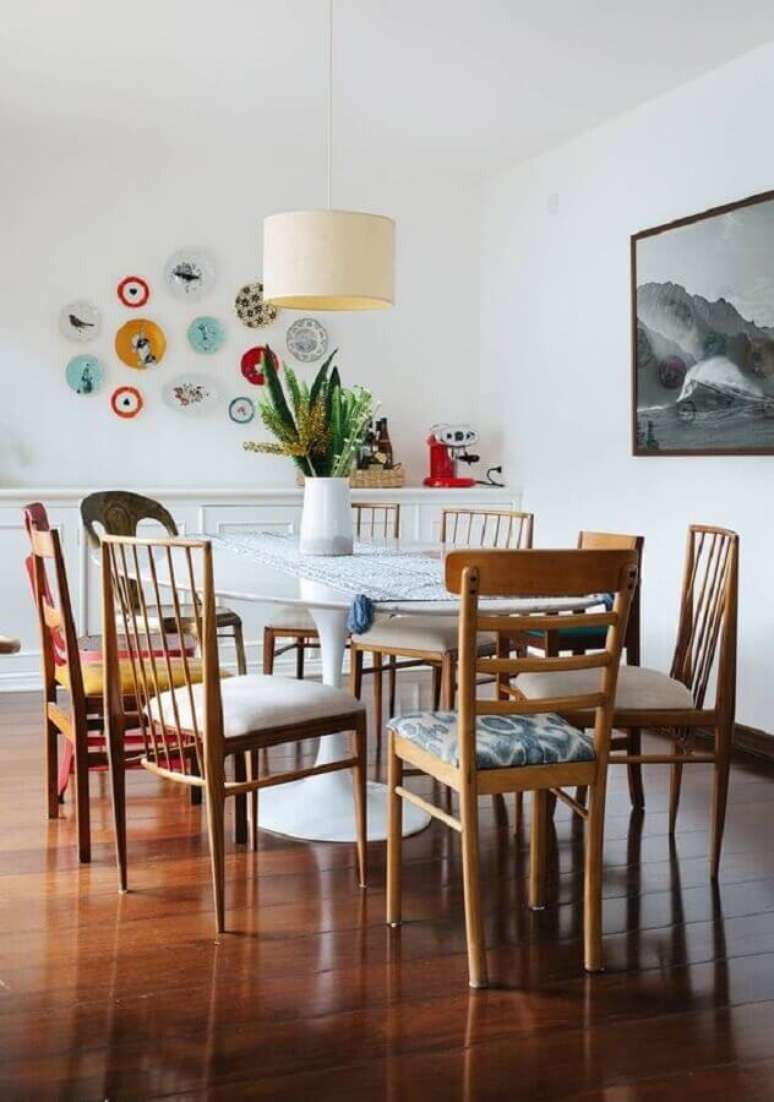 34. Sala de jantar decorada com cadeiras de madeira e vaso para decorar mesa de jantar – Foto: Histórias de Casa