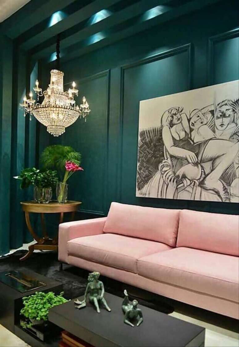 21. Decoração de sala verde sofisticada com lustre de cristal e sofá rosa – Foto: Simples Decoração