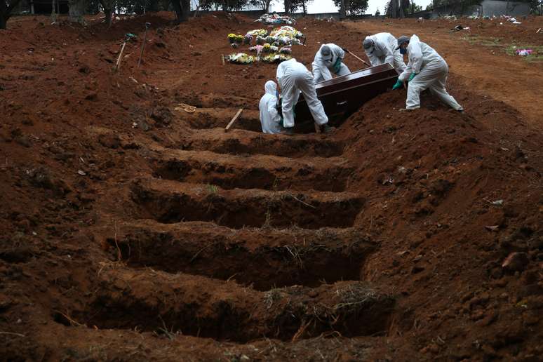 Coveiros com trajes de proteção enterram homem que morreu devido à Covid-19 em cemitério de São Paulo
04/06/2020
REUTERS/Amanda Perobelli