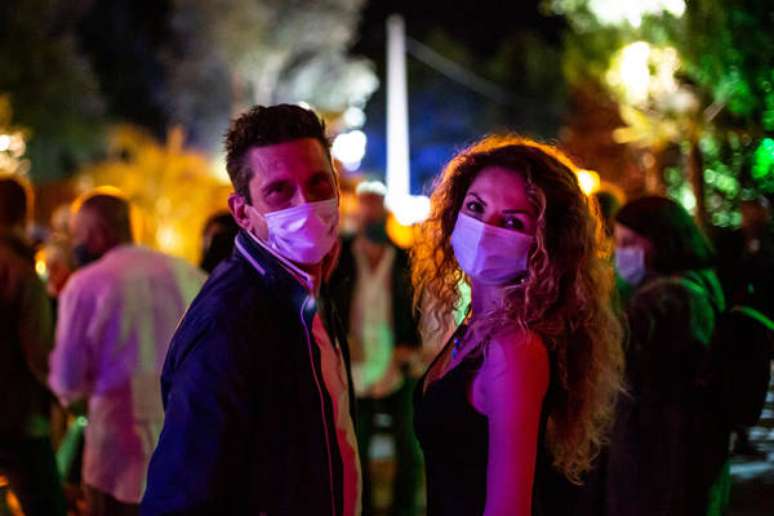 Clientes com máscaras de proteção em espaço para eventos em Bolonha, norte da Itália