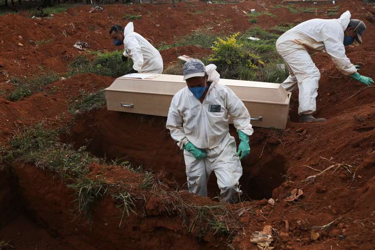 Coveiros com trajes de proteção fazem o sepultamento de uma pessoa que morreu infectada pelo novo coronavírus, no cemitério de Vila Formosa, em São Paulo
22/05/2020
REUTERS/Amanda Perobelli