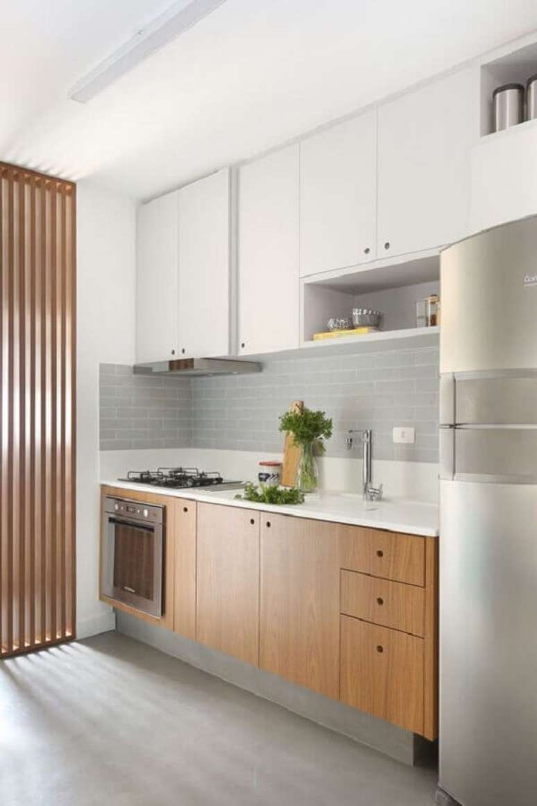 25. Decoração moderna com faixa de azulejo para cozinha branca com gabinete de madeira planejado – Foto: Pinterest
