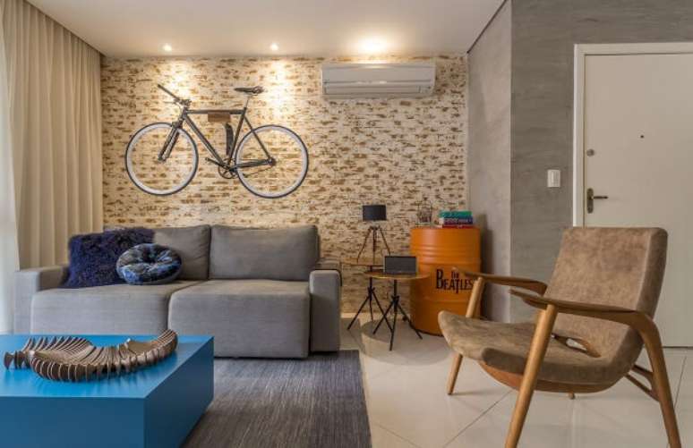 2. Ambiente descontra&iacute;do com sof&aacute; retr&aacute;til pequeno cinza. Projeto por Fl&aacute;via Campos Arquitetura