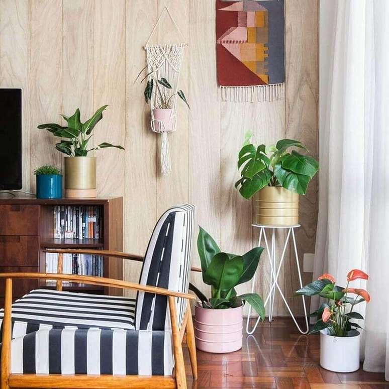62. Vasos com plantas para decoração de sala de estar com poltrona listrada de madeira – Foto: Behance