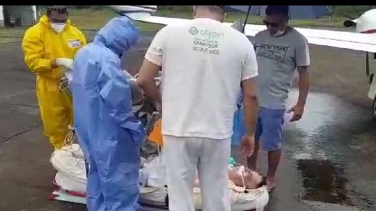 Depois de quase três horas sob o sol quente do Amapá, seu Evandro toma chuva no chão do aeroporto antes de embarcar no avião UTI