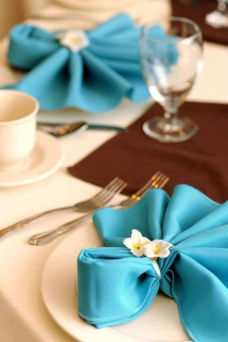 13. Como dobrar guardanapo de tecido azul com flores decorativas – Via: Pinterest