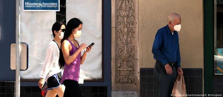 Pessoas com máscaras faciais caminham por Pasadena, na Califórnia