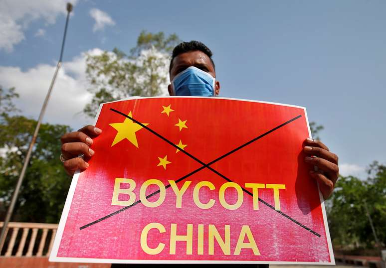 Manifestante na Índia mostra cartaz defendendo boicotes contra a China. 18/6/2020. REUTERS/Amit Dave