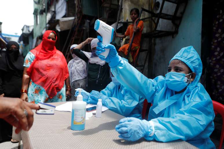 Profissional de saúde em trajes de proteção checa temperatura de morador em área de favela em Mumbai, na Índia
30/06/2020 REUTERS/Francis Mascarenhas