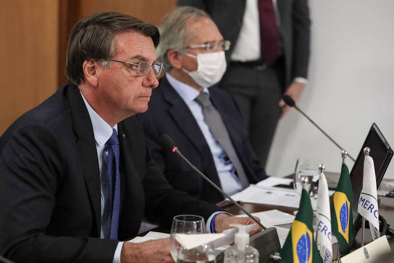 O presidente Jair Bolsonaro ao lado do ministro Paulo Guedes durante videoconferência da cúpula do Mercosul.