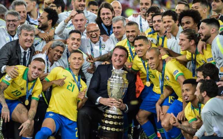 Em 2019, Bolsonaro tirou foto com taça da Copa América no Brasil junto do elenco (Foto: CARL DE SOUZA / AFP)