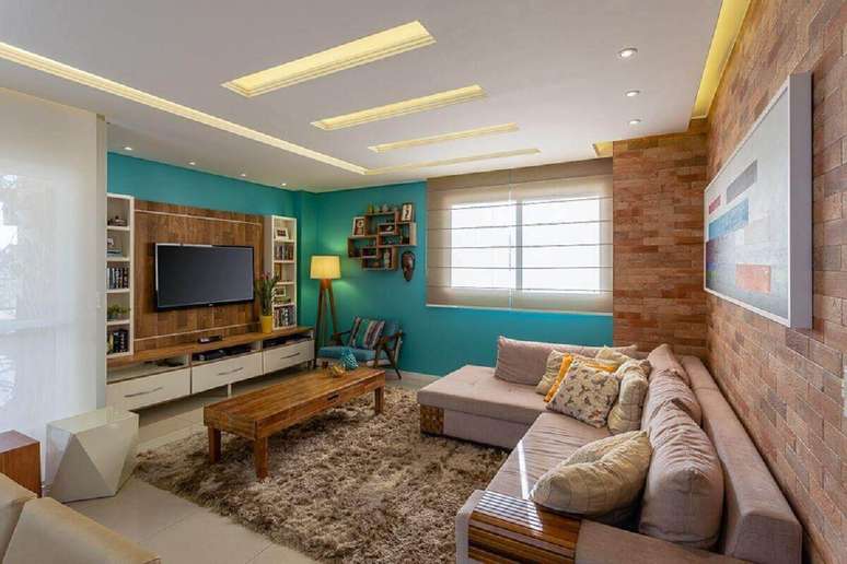 2. Sala com tapete felpudo e sofá confortável com almofadas – Foto: Mais Art & Design