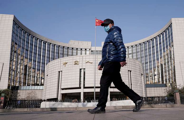Homem de máscara passa pela sede do Banco do Povo da China, o banco central do país, em Pequim. 3 de fevereiro de 2020. REUTERS/Jason Lee