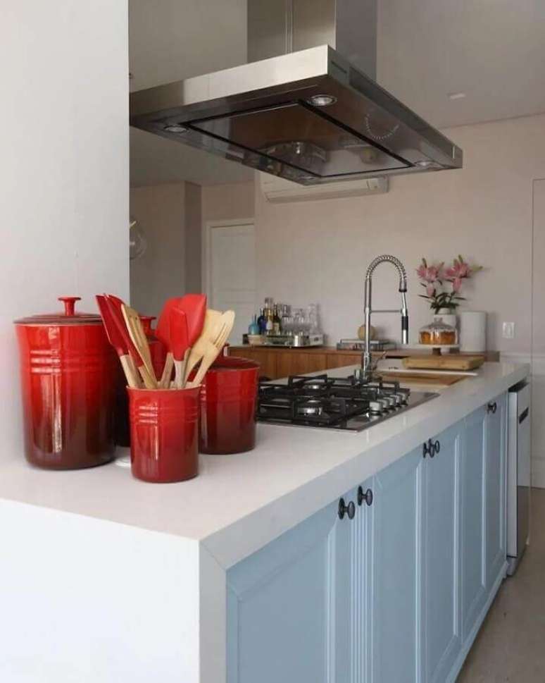 25. Cozinha com ilha decorada com portas de arm&aacute;rios em tons de azul pastel &ndash; Foto: Quattrino Arquitetura