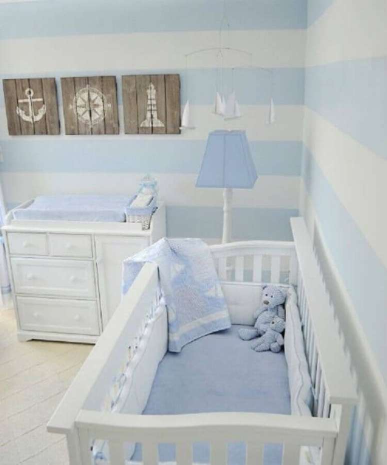47. Quarto de beb&ecirc; decorado com tema marinheiro com papel de parede azul pastel e branco listrado &ndash; Foto: Mil Dicas de M&atilde;e