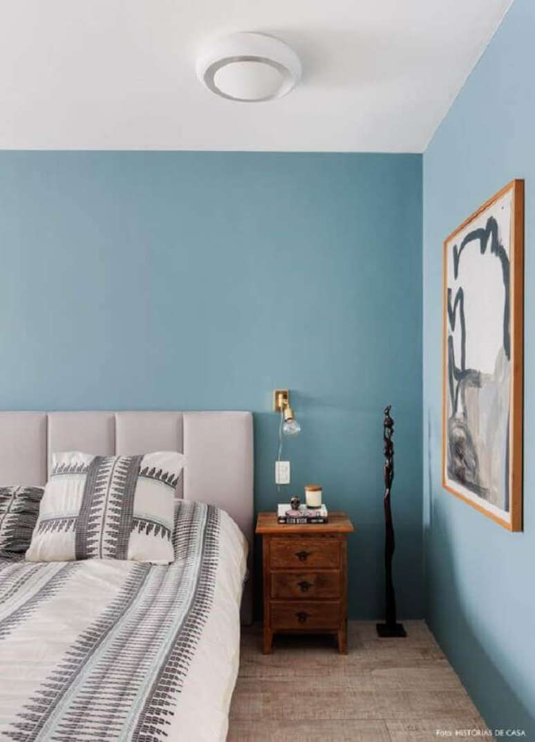 56. Tinta azul pastel para decora&ccedil;&atilde;o de quarto com cabeceira estofada cinza e criado mudo de madeira &ndash; Foto: Hist&oacute;rias de Casa
