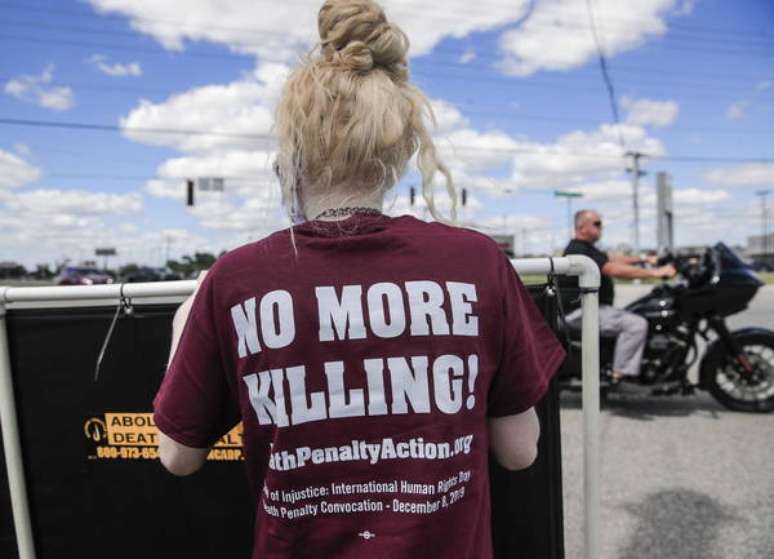 Mulher protesto em frente a uma penitenciária em Indiana contra a retomada das execuções federais