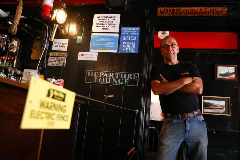 Johnny McFadden, dono do pub Star Inn, em St Just, na Inglaterra, posa para foto ao lado de cerca elétrica instalada para manter distanciamento social no bar
14/07/2020 REUTERS/Tom Nicholson  