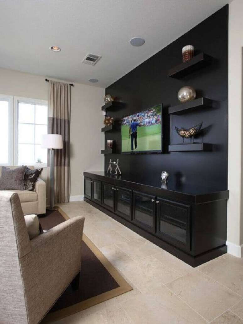 31. Decoração com rack preto para sala de estar com poltrona bege – Foto: Houzz