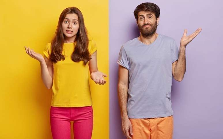 Homem e mulher em um fundo de cores diferentes, fazendo sinal de confusão