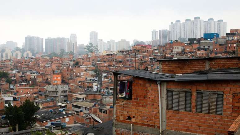 Casas em Paraisópolis, com prédios ao fundo